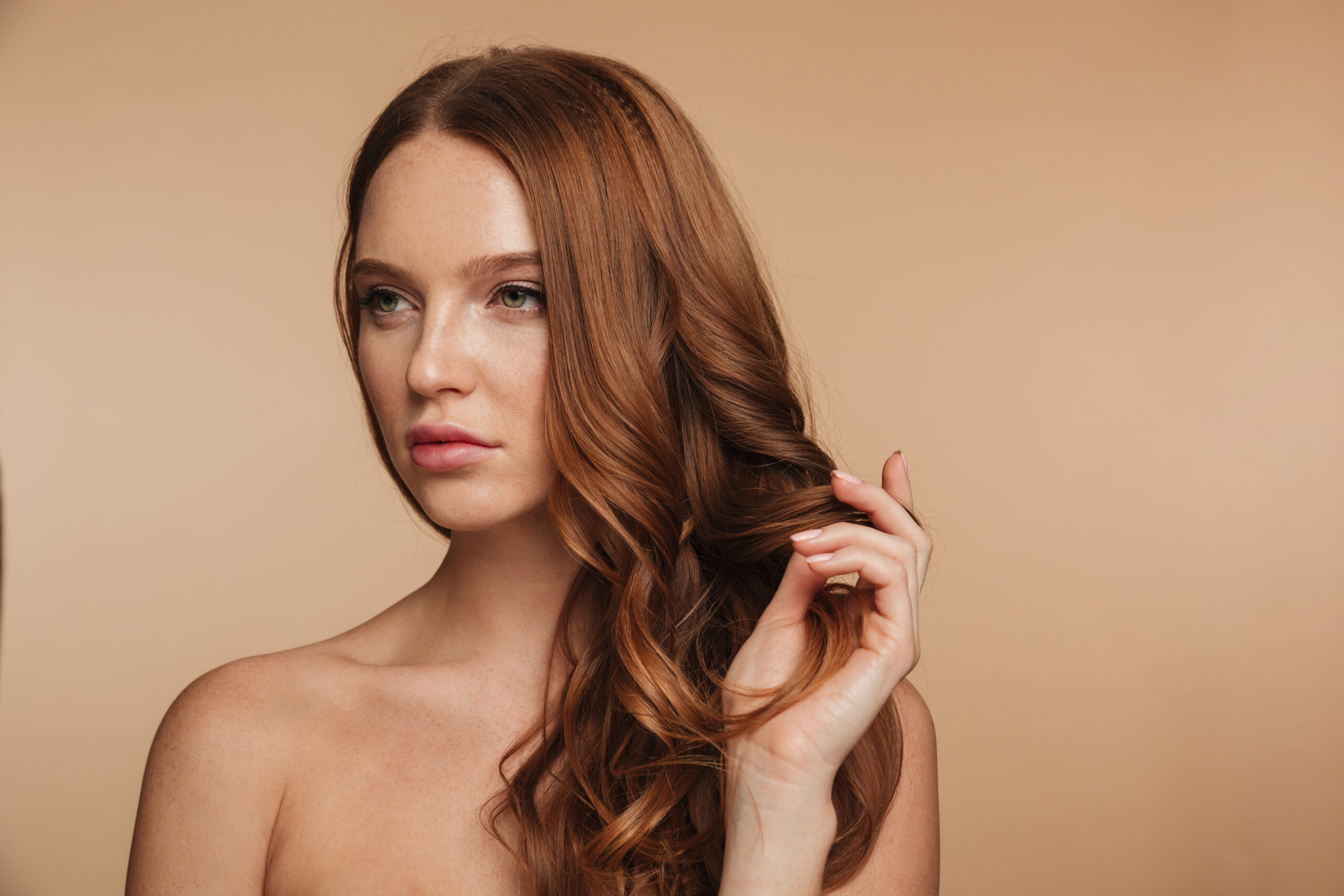 Beauty portrait of pretty ginger woman with long hair posing